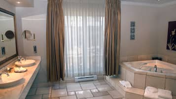 A bathroom with two sinks, a bathtub, and a large mirror.