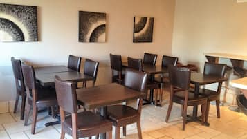 Un espace repas comprenant plusieurs tables et chaises, disposées de manière à créer un aménagement spacieux.