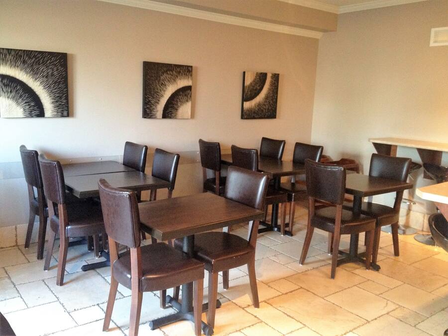 Un espace repas comprenant plusieurs tables et chaises, disposées de manière à créer un aménagement spacieux.