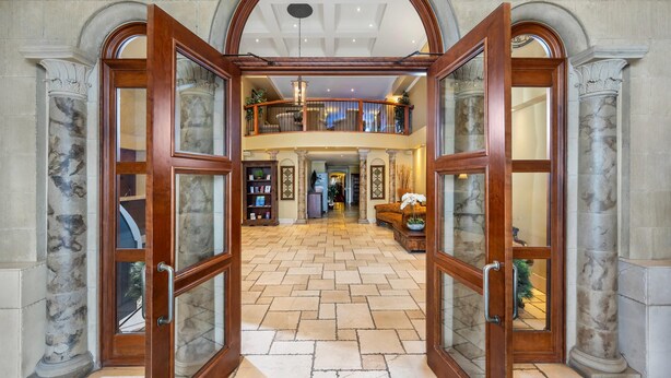 A grand foyer with a high ceiling, marble columns, and a central open space leading to a second-floor balcony. - Hotel Brossard, an Ascend Collection Hotel (Brossard)