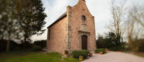 A small, rustic church with a steeply pitched roof and a central tower.