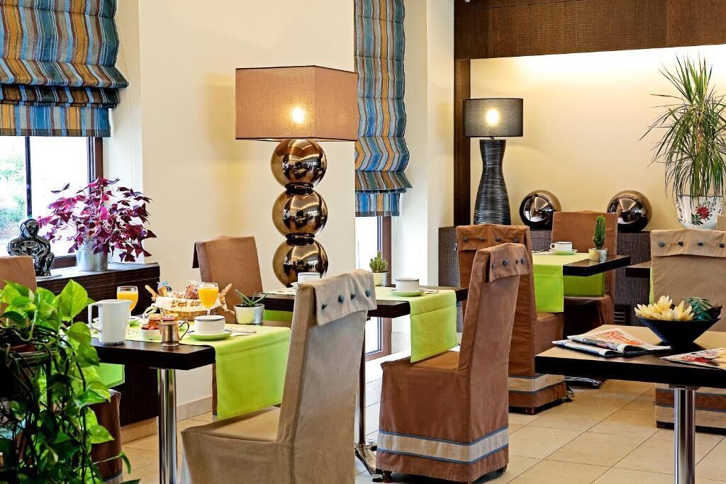 A hotel lobby with seating areas, tables, and decorative lamps.