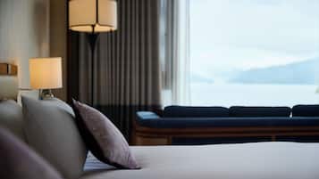 Une chambre d’hôtel avec un lit, une lampe, un canapé et une vue sur la mer.