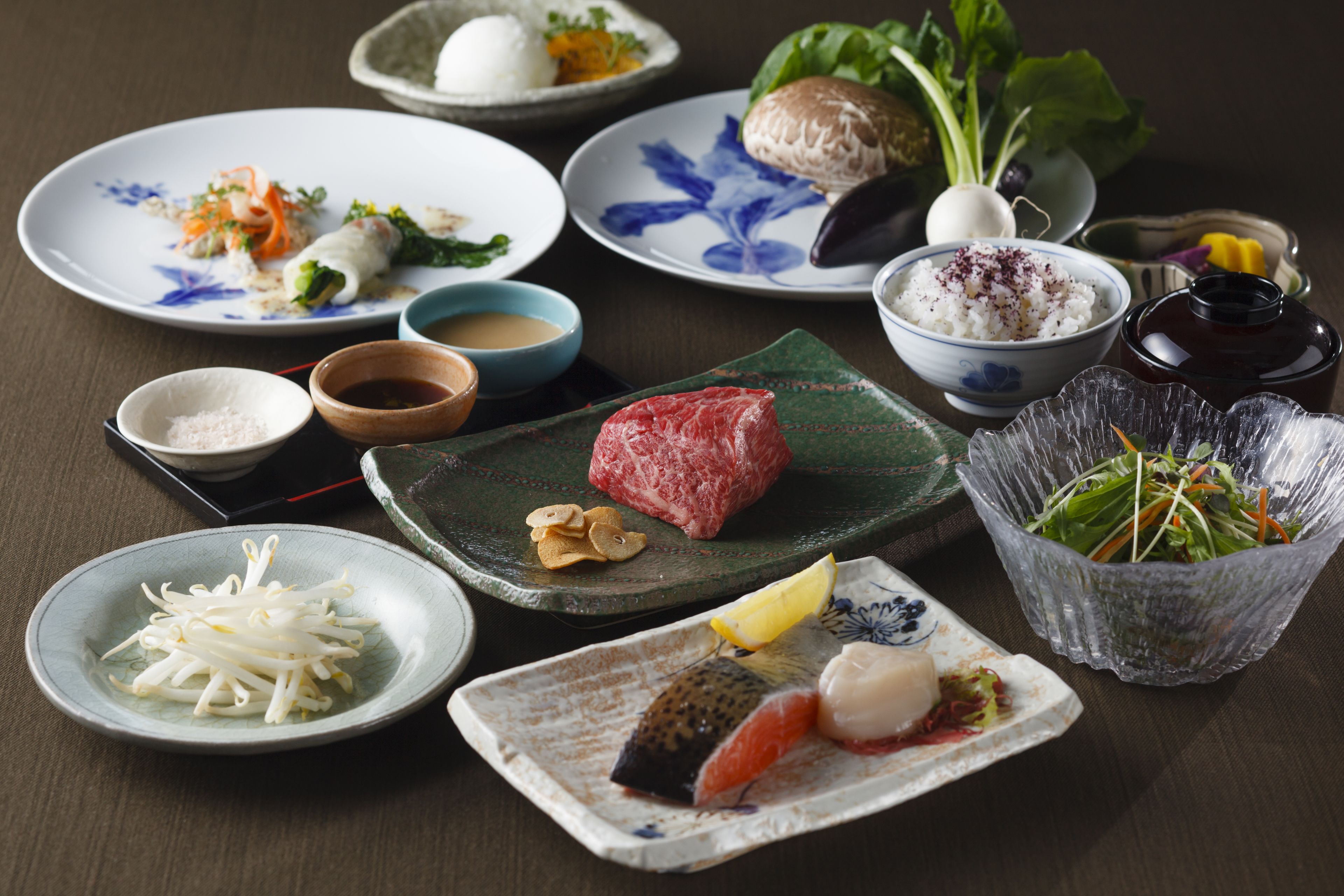 Variedad de platillos, incluyendo sushi, sashimi y un bol de arroz.