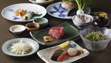 Variedad de platillos, incluyendo sushi, sashimi y un bol de arroz.
