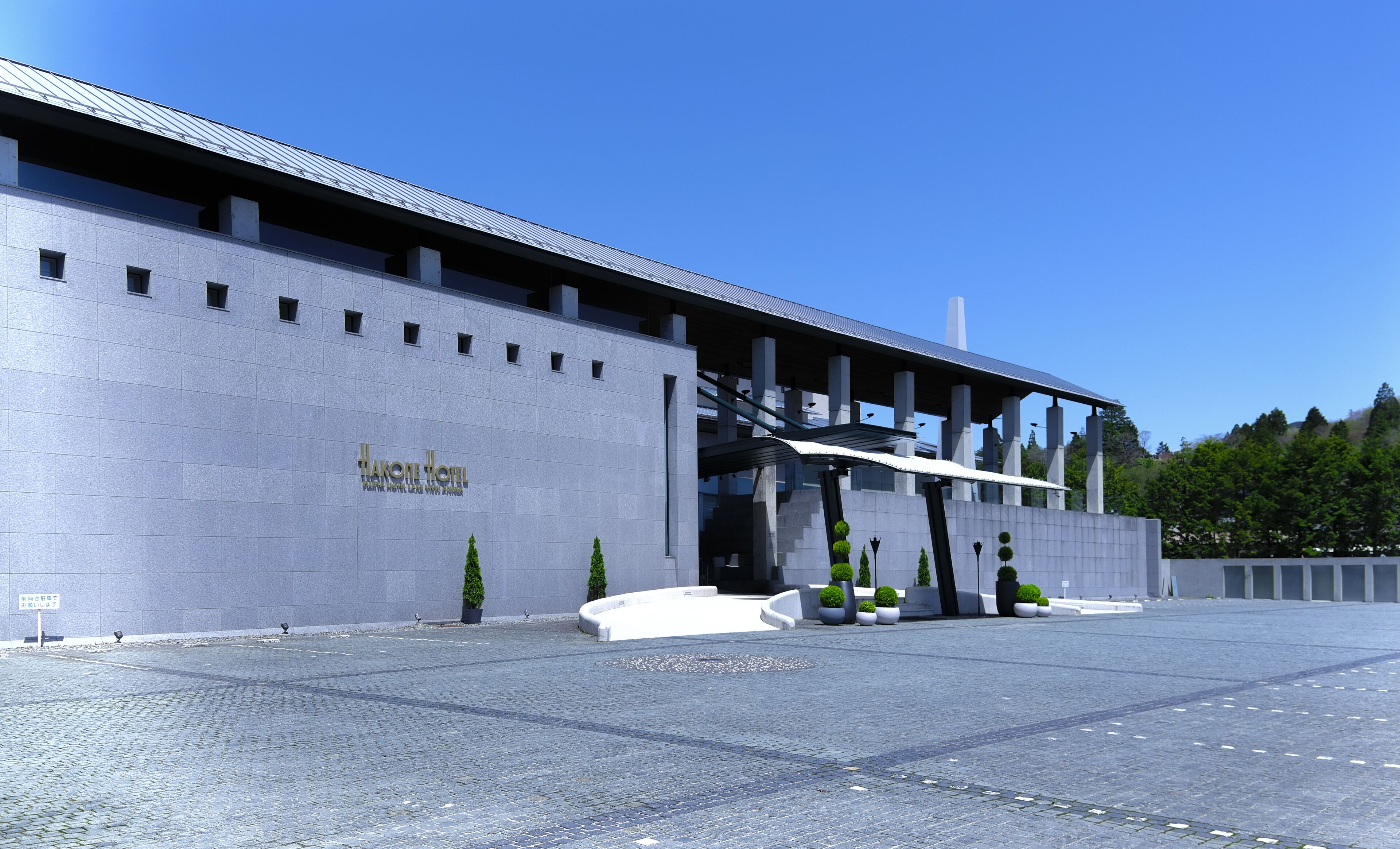 A modern building with a flat roof and a sign reading "Hakone Hotel".