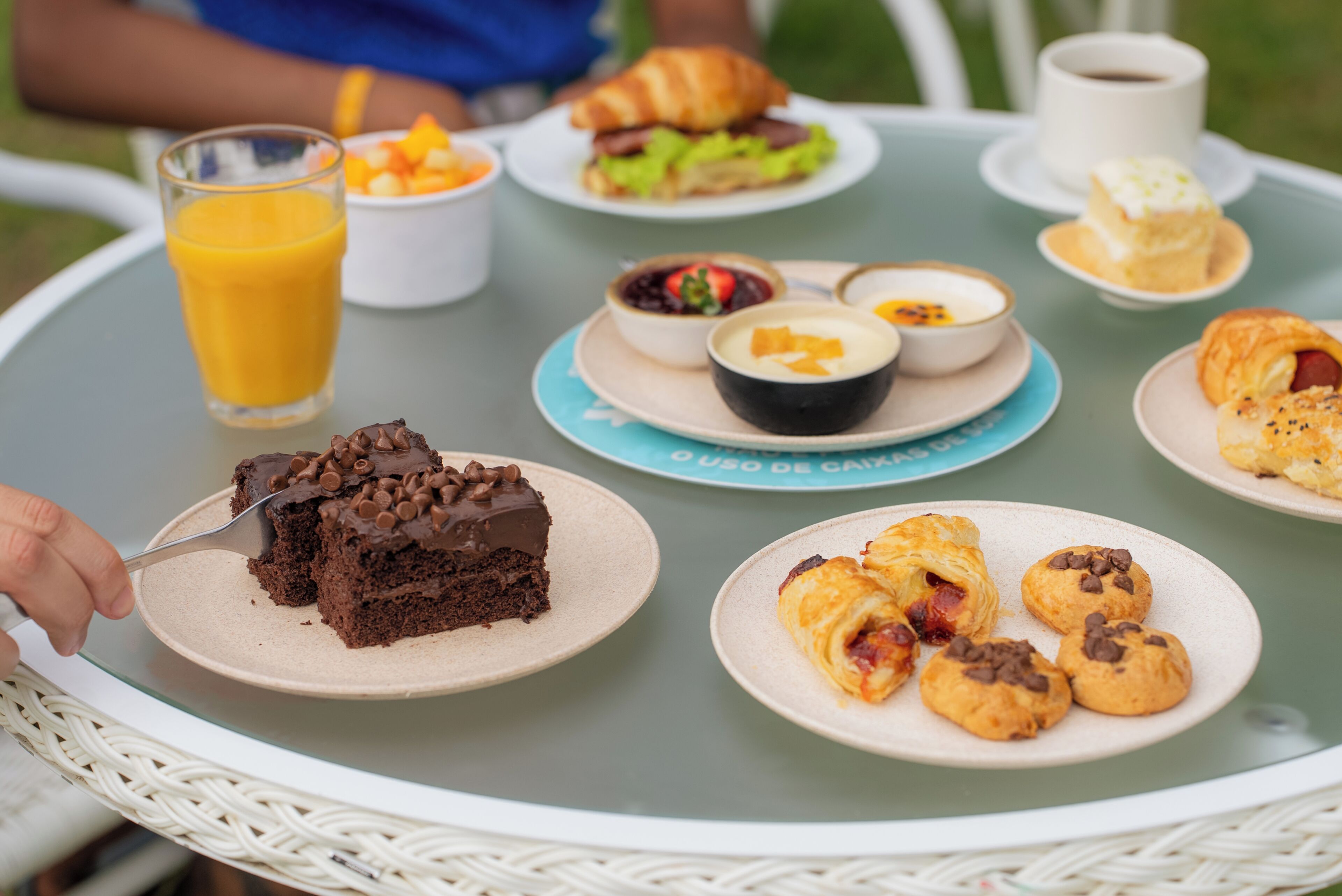 A table with various food items and a glass of orange juice.