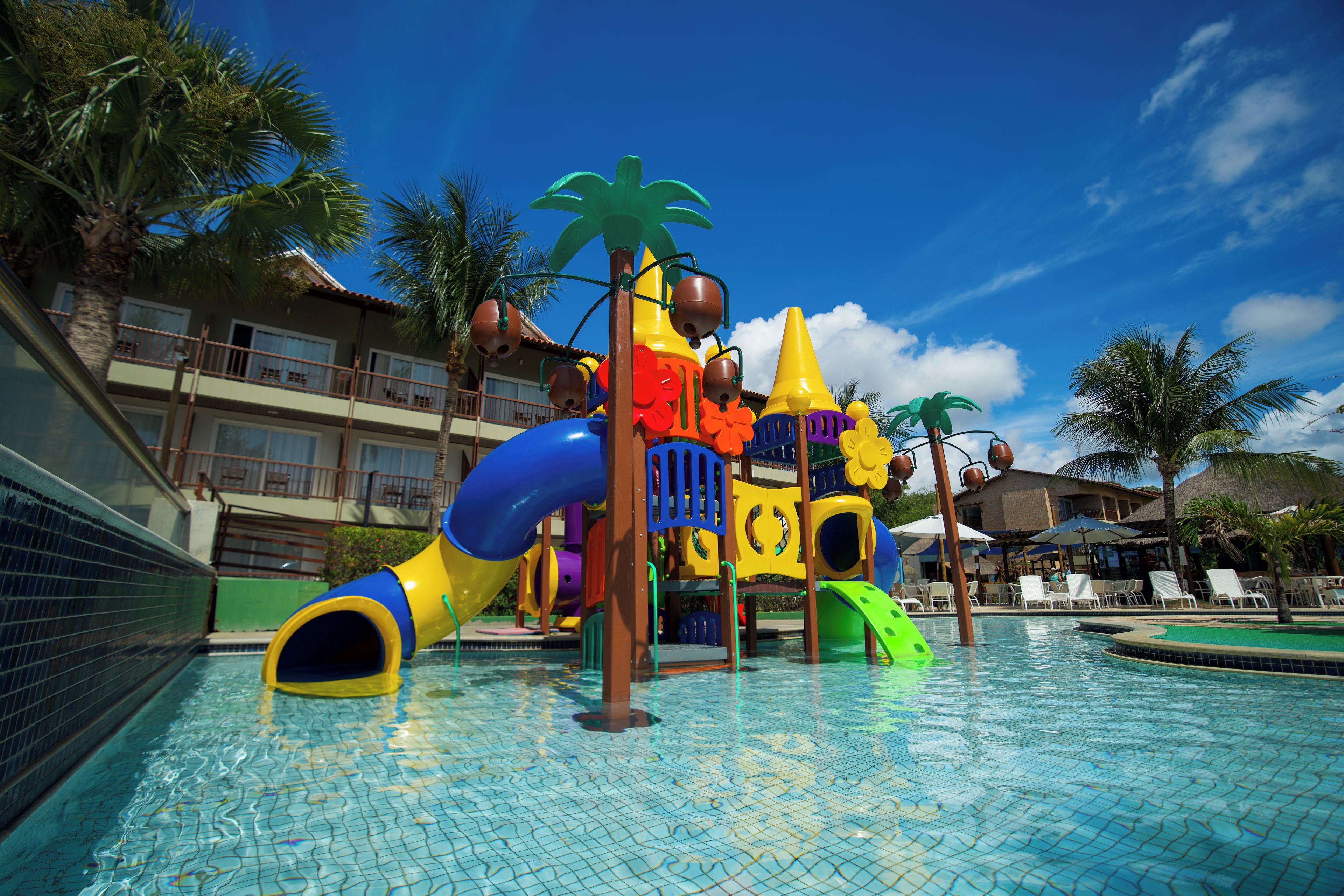 A children's play area with slides and climbing structures over a swimming pool.