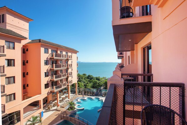 A multi-story hotel with a pool area, balconies, and a view of the sea. - Hotel Jurerê Beach Village - OFICIAL (Florianópolis)