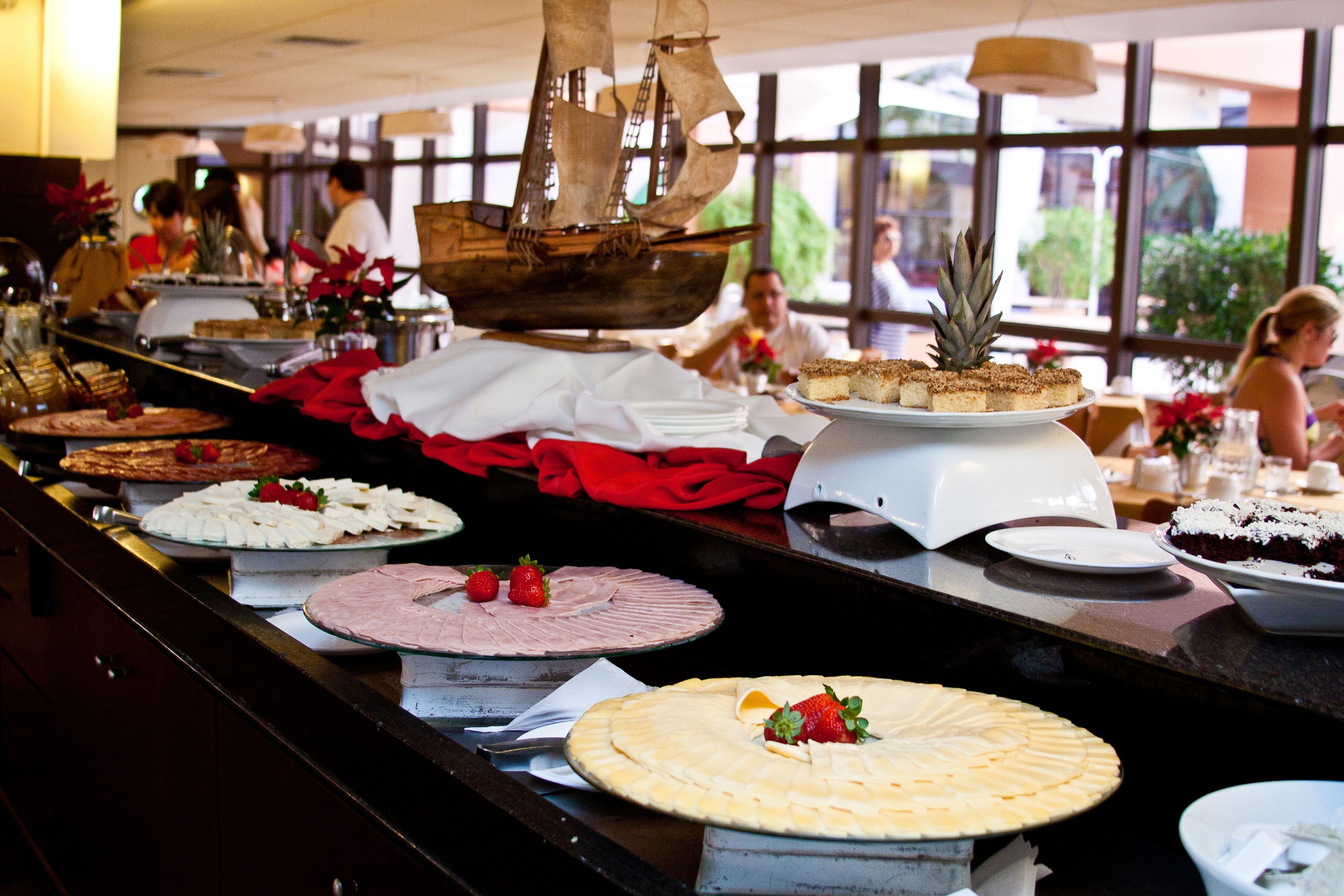 A buffet with various desserts and a decorative ship centerpiece.