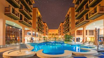Relax by the pool surrounded by walkways, balconies, and lush greenery.