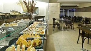A buffet setup with various food items and a dining area with tables and chairs.