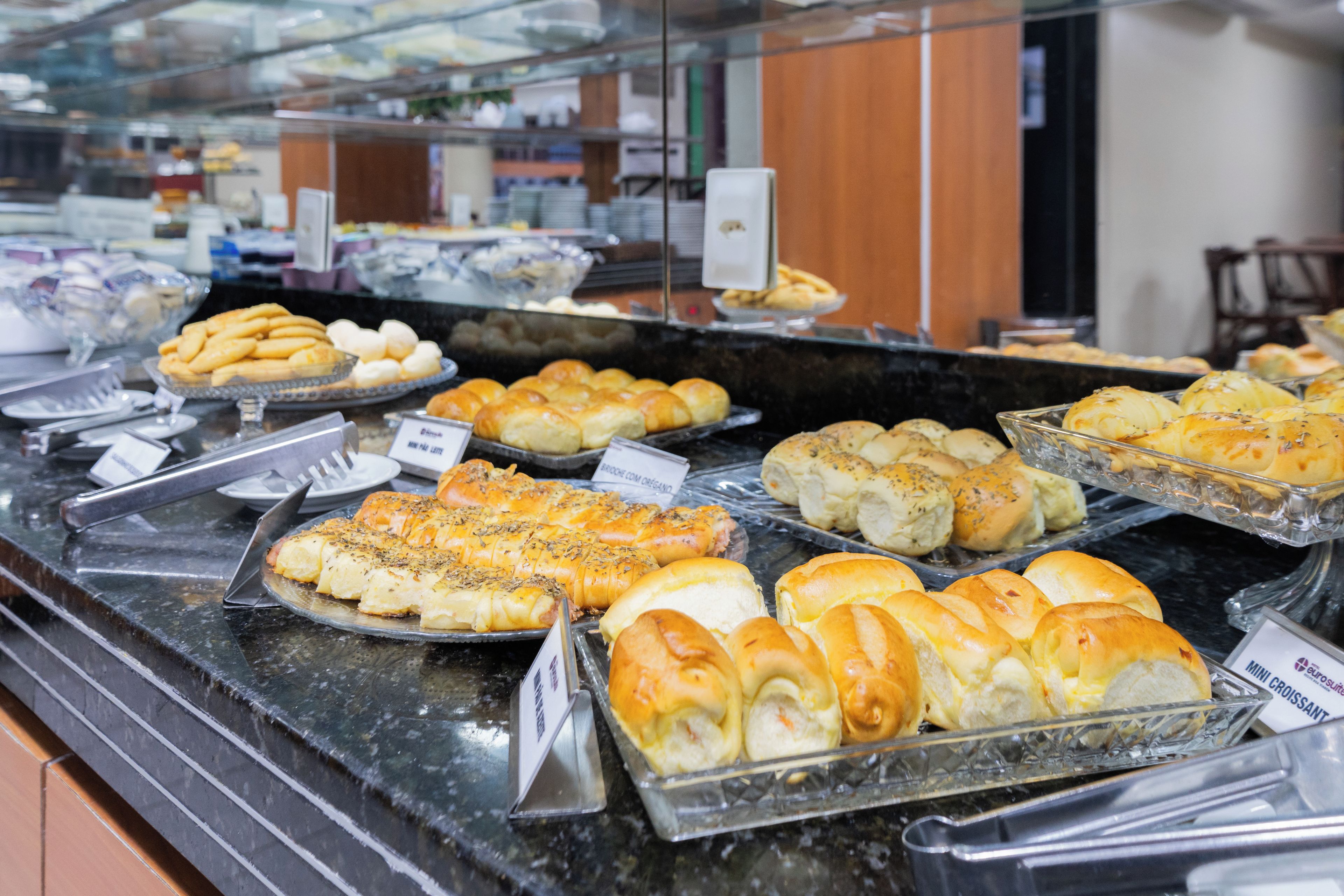 Un bufé con diversas opciones de panadería expuestas en recipientes de vidrio.