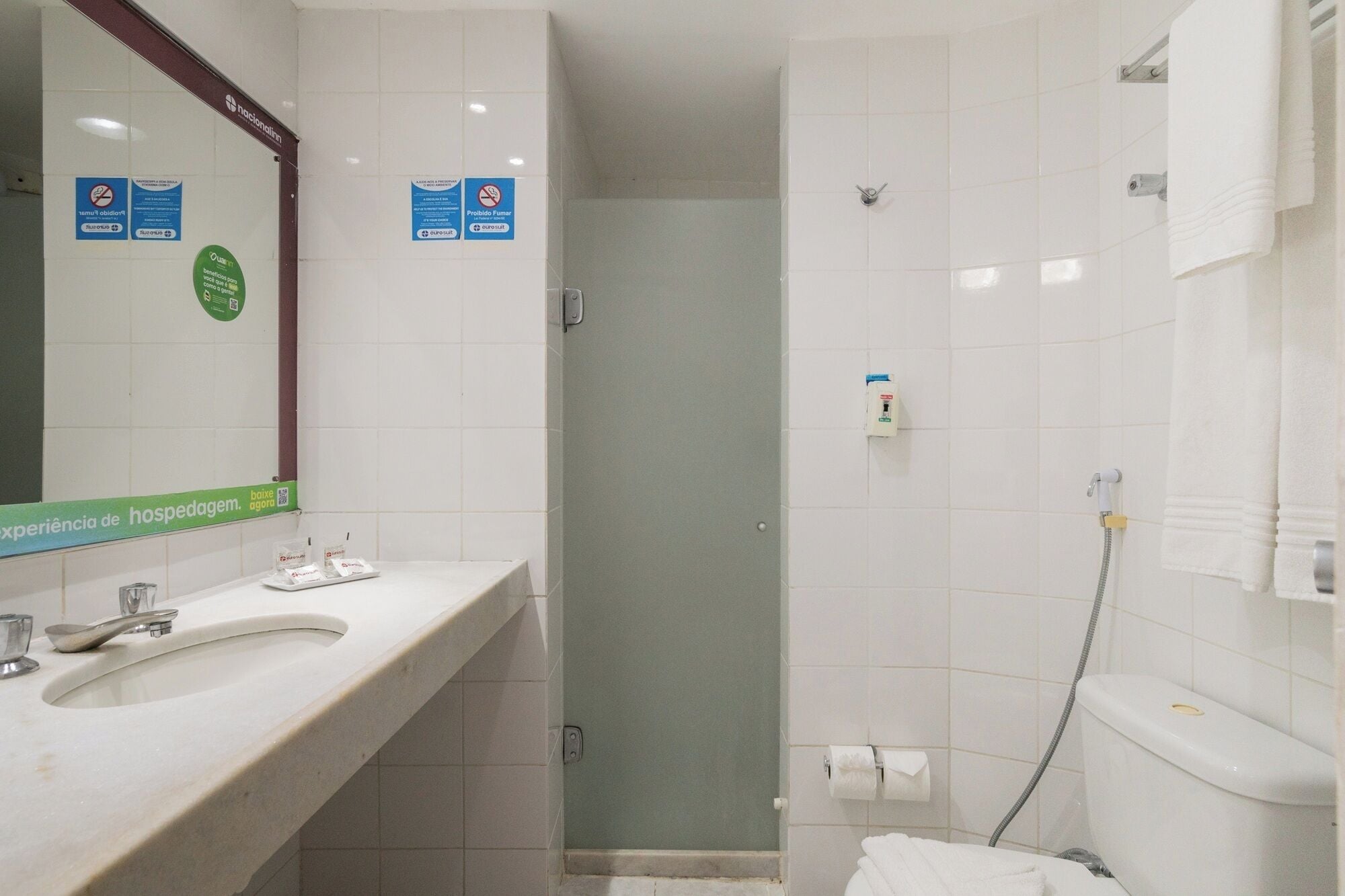 A bathroom with a sink, mirror, shower, and toilet.