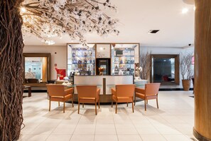 A bar area with a counter, seating, and a display of bottles. - Hotel Euro Suíte Recife Boa Viagem By Nacional Inn (Recife)