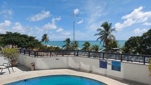 A swimming pool with a view of the beach and palm trees. - Hotel Euro Suíte Recife By Nacional Inn (Recife)