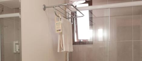 A bathroom with a granite countertop sink, a toilet, a shower stall, and a mirror.