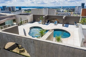 Una piscina al aire libre, sombrillas, tumbonas