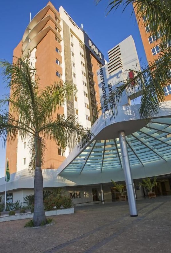 Un hotel moderno con una entrada de vidrio curva distintiva y un llamativo letrero que dice 'Hotel'.