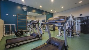 A gym with treadmills, ellipticals, and weight machines. - Astron Hotel Bauru by Nobile (Bauru)