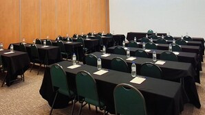 Ein Konferenzraum mit mehreren Tischen und Stühlen, ausgestattet mit Wasserflaschen und Namensschildern.