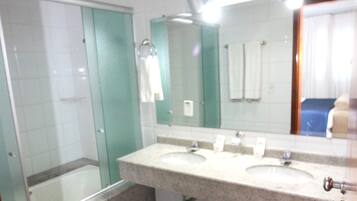 Un baño con dos lavamanos, una cabina de ducha de vidrio y un espejo.