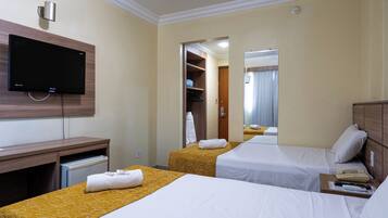 A hotel room with two beds, a TV, a desk, and a wardrobe.