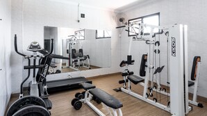 A gym with cardio equipment, weight machines, and a bench. - Carlton Plaza São José dos Campos (São José dos Campos)