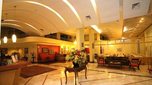 A spacious lobby with a reception desk, seating area, and a balcony. - Carlton Plaza São José dos Campos (São José dos Campos)
