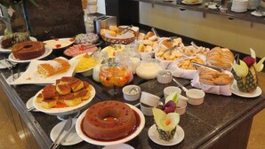 A buffet with various food items including cakes, pastries, and fruits. - Carlton Plaza São José dos Campos (São José dos Campos)