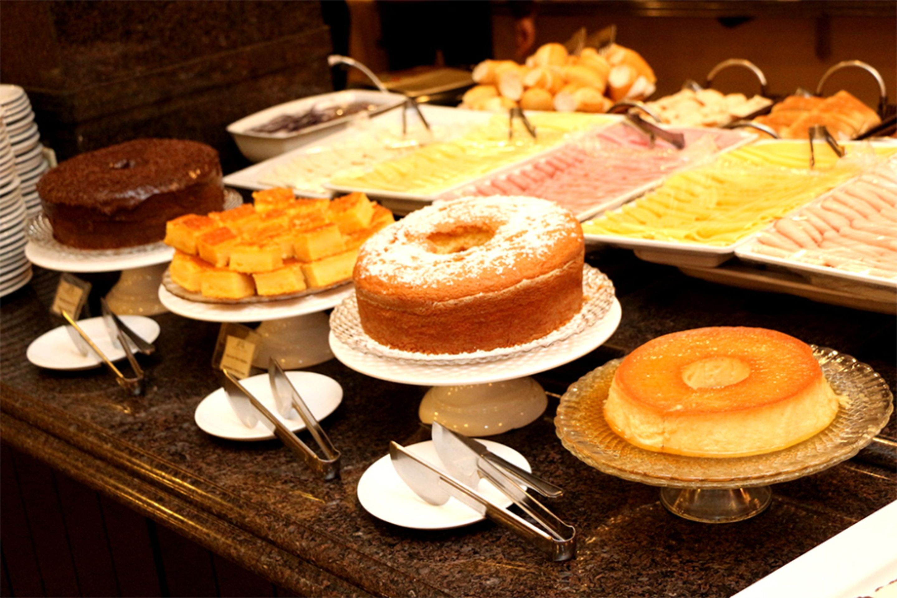 A buffet with various desserts including cakes and pastries.