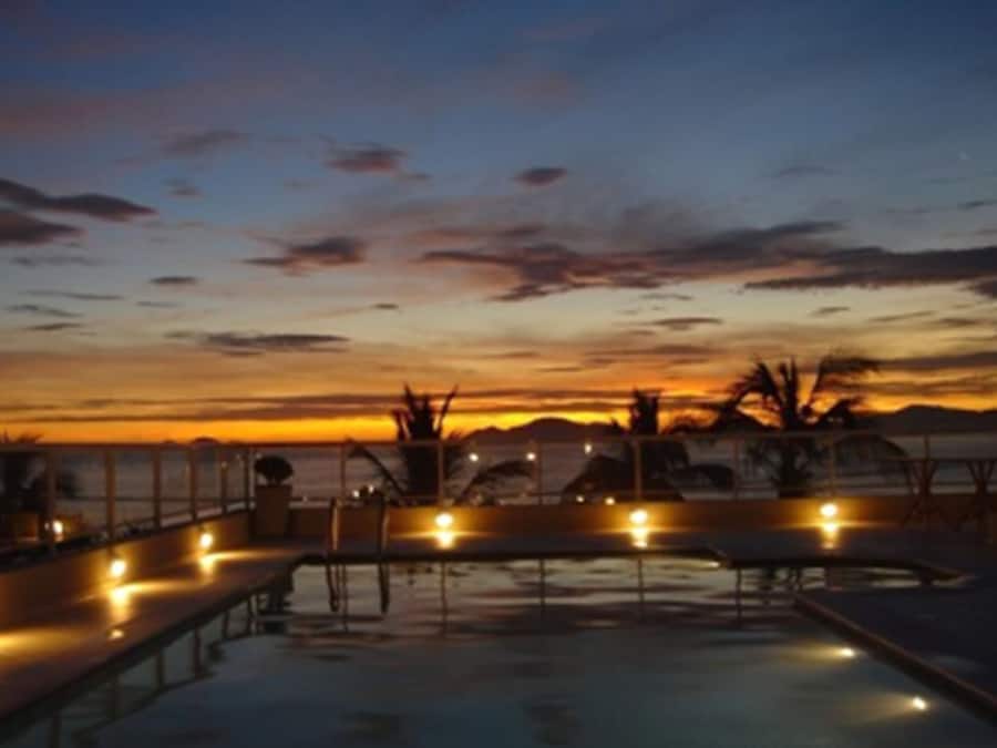 Una piscina al aire libre, sillones reclinables de piscina