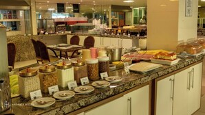 A buffet setup with various food items and condiments. - Rede Andrade Solmar (João Pessoa)