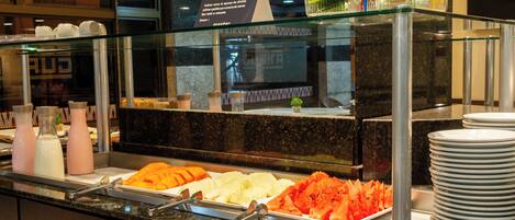 A buffet with various food items and condiments.