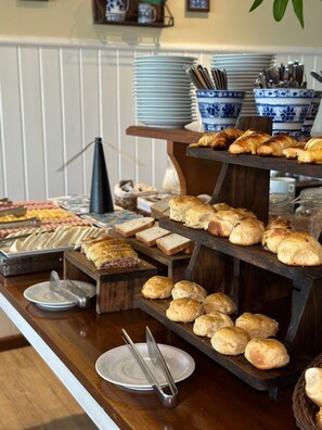 A buffet with various baked goods and pastries on display. - Pousada Corsário Búzios (Búzios)