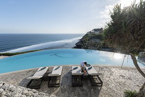 Una piscina al aire libre, camas de piscina gratis, sombrillas