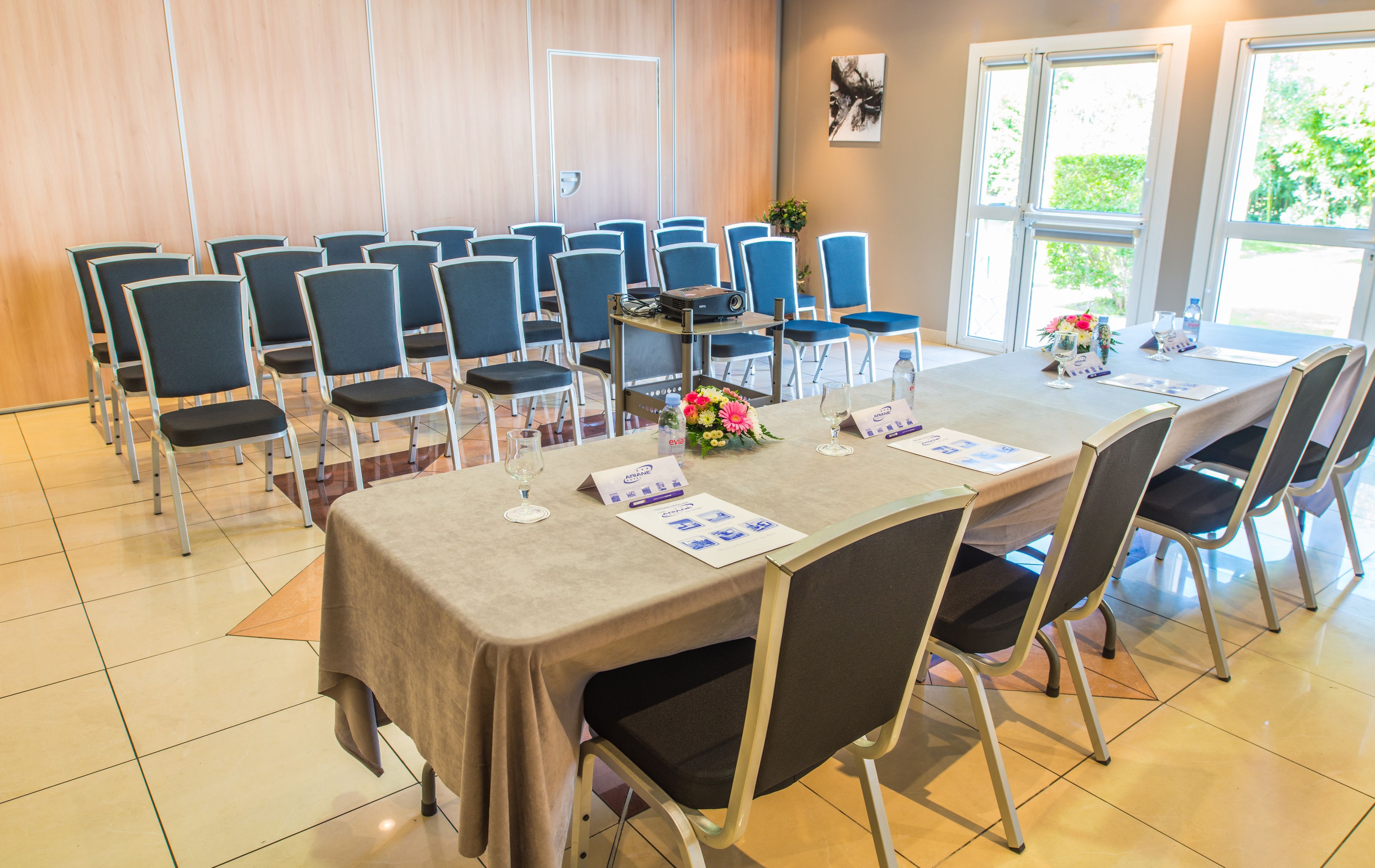 A conference room with a long table, chairs, and a projector.