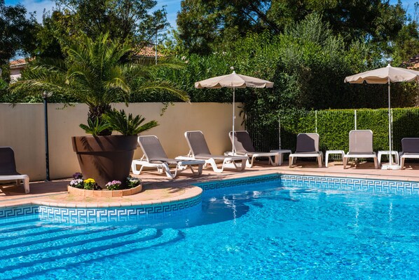 Seasonal outdoor pool, open 9:00 AM to 10:00 PM, pool loungers