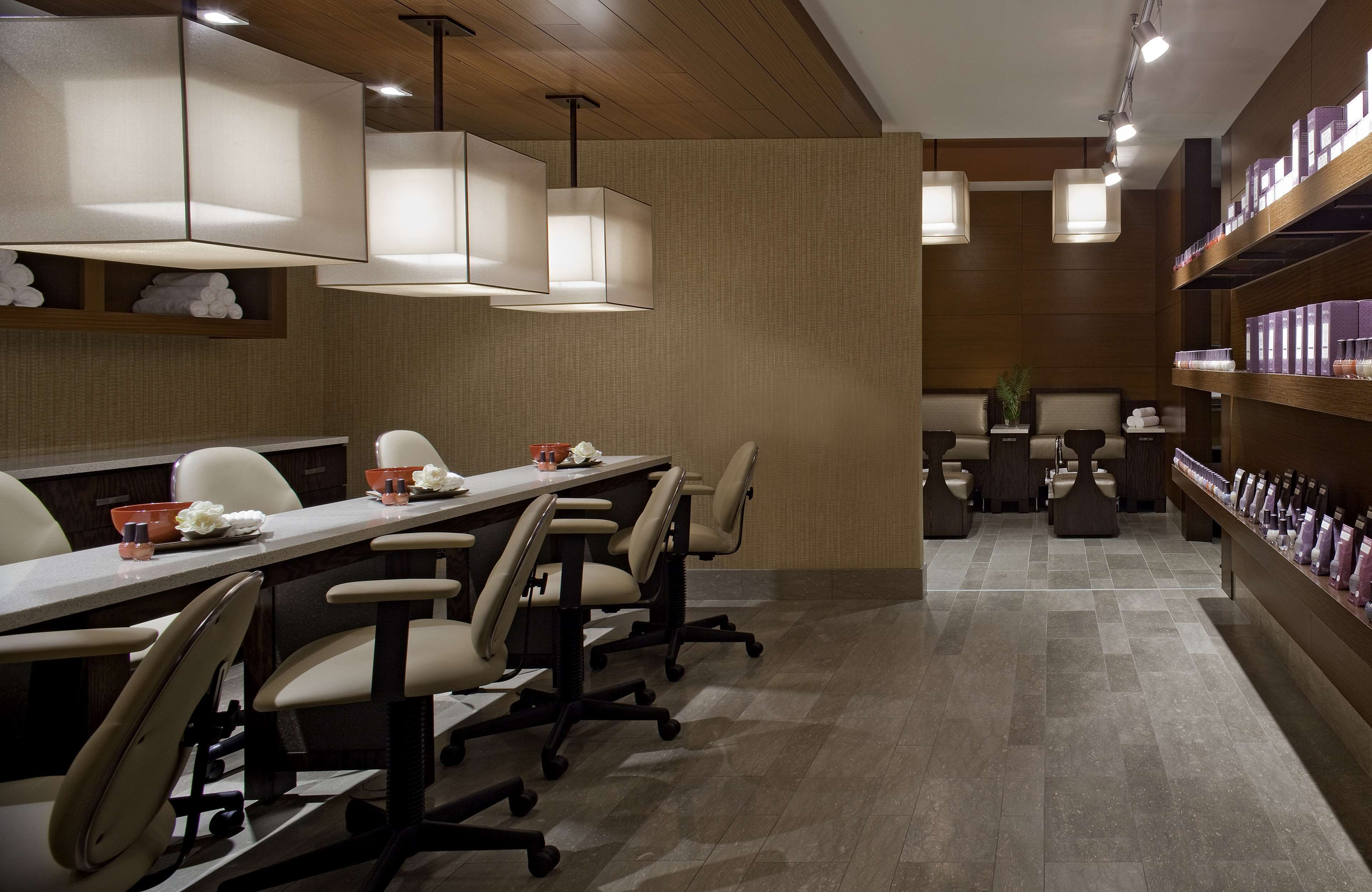 A modern conference room with a long table, chairs, and pendant lighting.