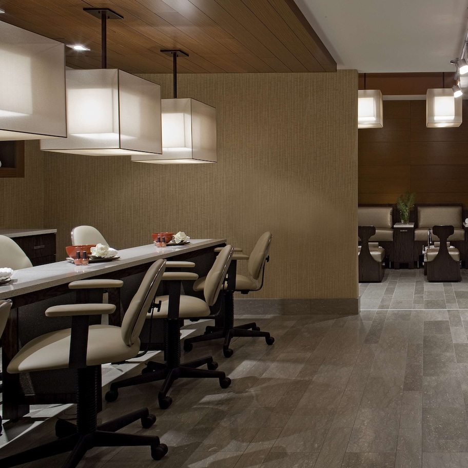 A modern conference room with a long table, chairs, and pendant lighting.