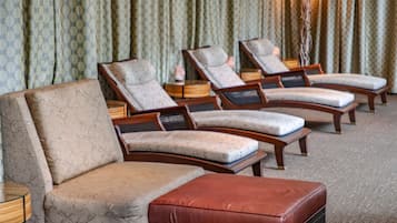 Ein Hotelzimmer mit einer Couch, zwei Sesseln und einem kleinen Hocker.