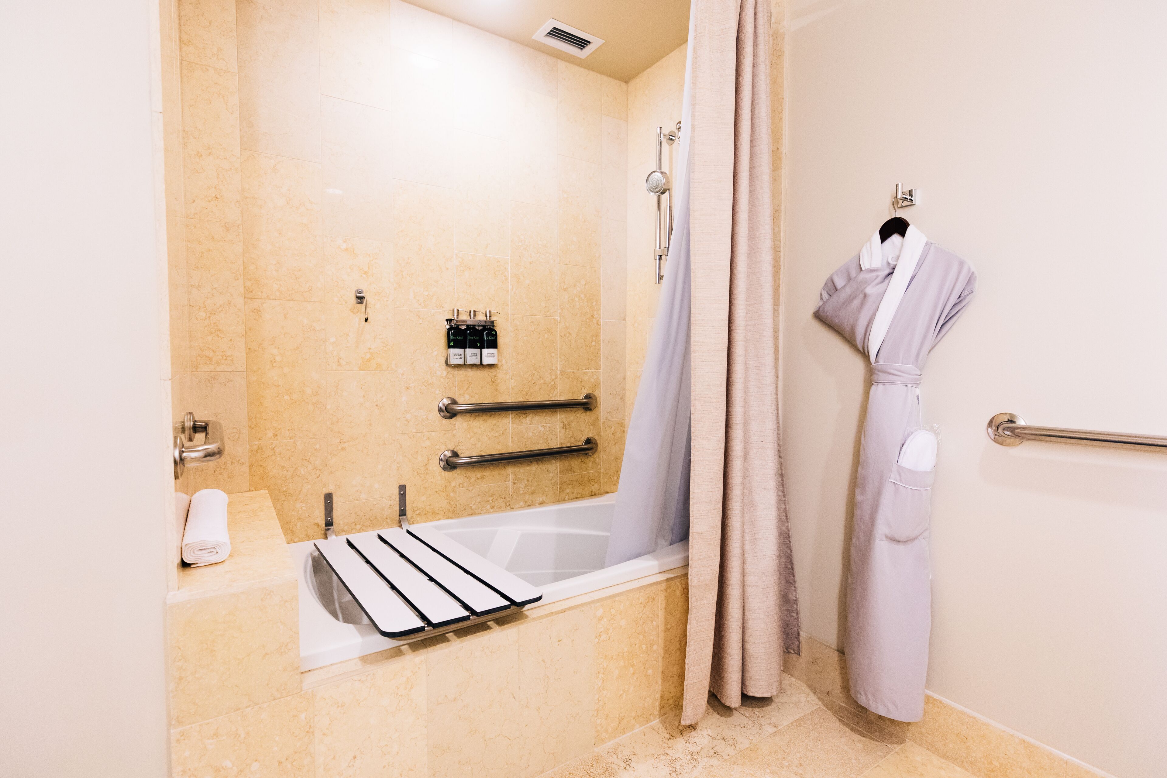A modern bathroom with a bathtub, a shower, and a towel rack.