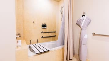 A modern bathroom with a bathtub, a shower, and a towel rack.