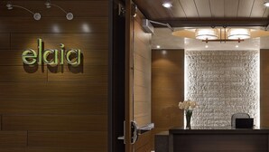 Un área de recepción con una pared de madera y una pared con textura de piedra detrás del mostrador.