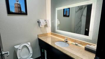 Une salle de bain moderne avec des toilettes, un lavabo et un grand miroir.
