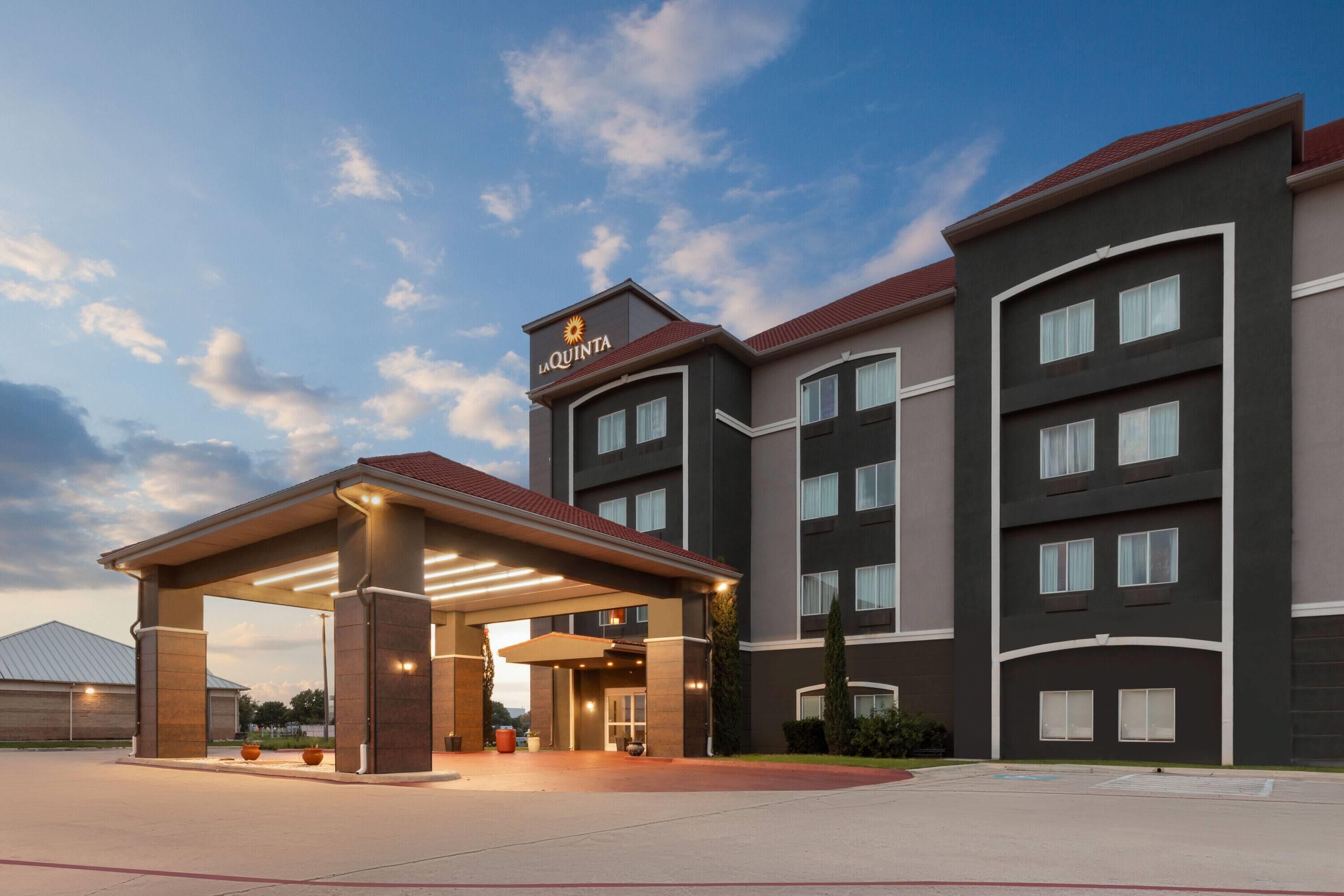 Et hotel med overdækket indgang, flere etager og et skilt med teksten "LA QUINTA".