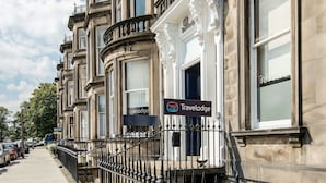 A row of classic, ornate buildings with 'Travelodge' signs, featuring large windows and detailed architectural details. - Travelodge Edinburgh Haymarket (Edinburgh)