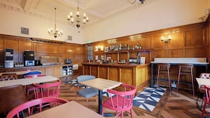 A restaurant with wooden paneling, a bar area, and tables with chairs. - Travelodge Edinburgh Haymarket (Edinburgh)