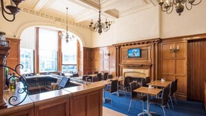 A spacious hotel lobby with a central bar, seating area, and a fireplace. - Travelodge Edinburgh Haymarket (Edinburgh)