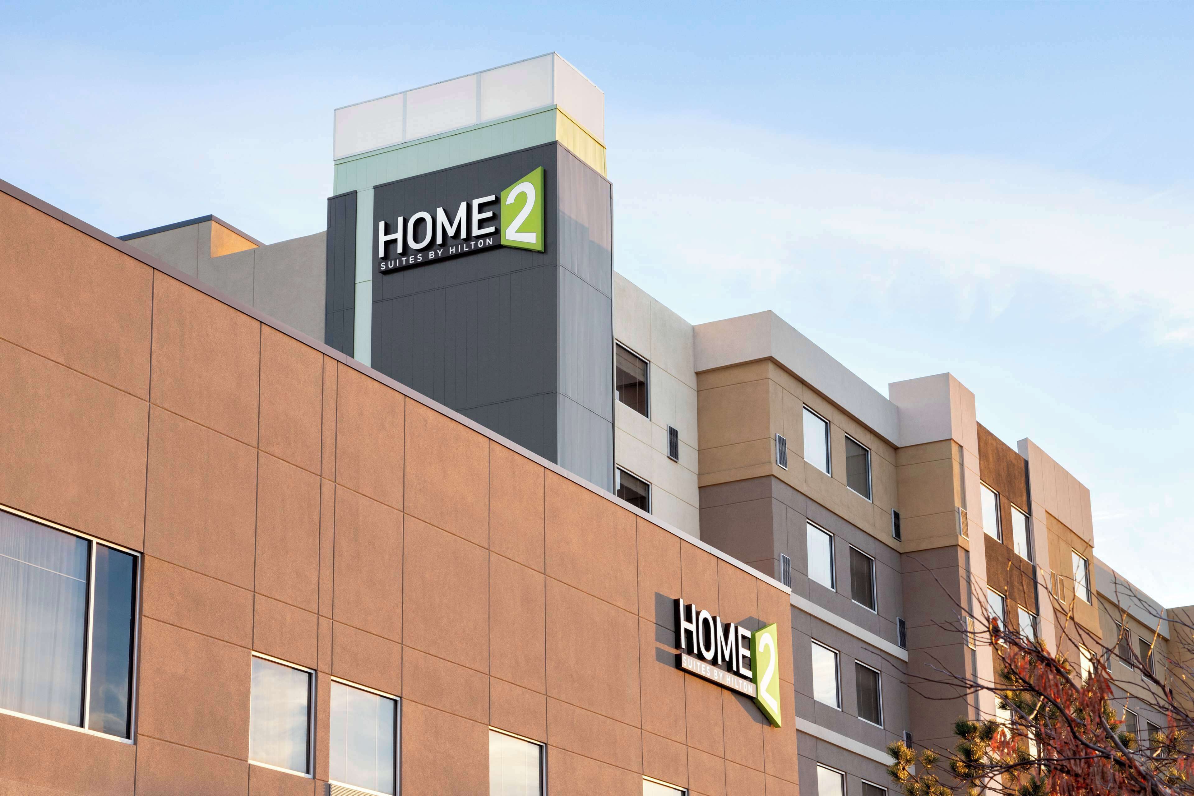 En moderne hotelbygning med skiltet "HOME 2", som angiver at det er en del af Hilton-hotelkæden.